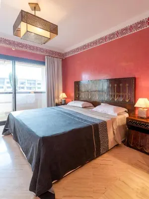 a bedroom with a large bed with red walls at Appart de luxe Hivernage Menara Mall Gueliz in Marrakech