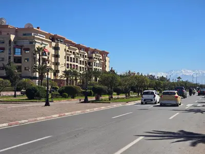 a street with cars driving down a road with a building at Appart de luxe Hivernage Menara Mall Gueliz in Marrakech
