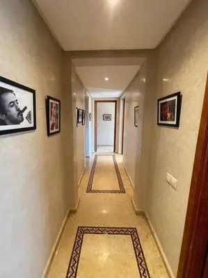 a hallway with a long hallway with pictures on the walls at Superbe appartement calme Hivernage in Marrakech