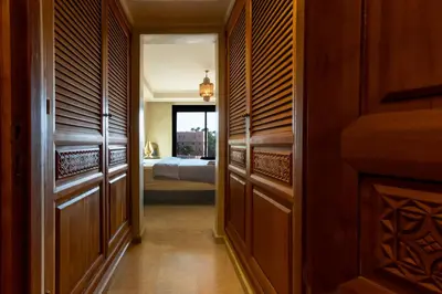 a hallway with wooden cabinets and a bedroom with a bed at Superbe appartement calme Hivernage in Marrakech