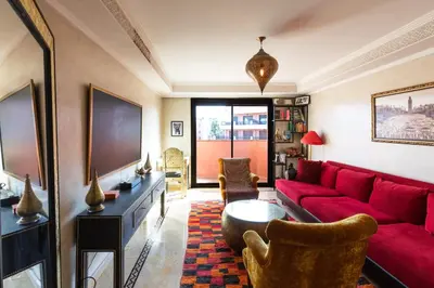 a living room with a red couch and a tv at Superbe appartement calme Hivernage in Marrakech