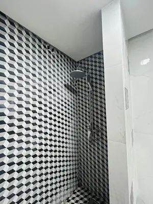 a bathroom with a shower with black and white tiles at Résidence Mirador MAJORELLE in Marrakech