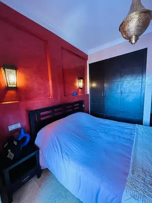 a bedroom with a bed and a red wall at Résidence Mirador MAJORELLE in Marrakech