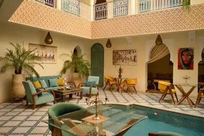a living room with a pool and tables and chairs at Riad Jalina in Marrakech