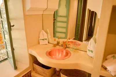 a bathroom with a sink and a mirror at Riad Jalina in Marrakech