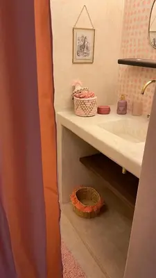 a bathroom with a sink and a shelf with a basket at Riad Dar Vevé - private fashion house in Marrakech