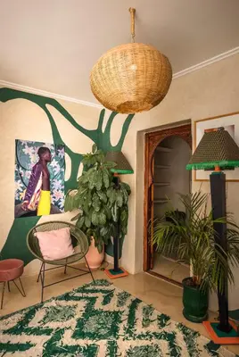 a living room with chairs and a painting on the wall at Riad Dar Vevé - private fashion house in Marrakech