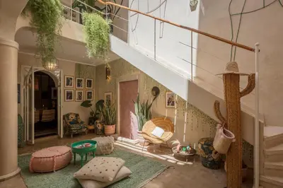 a living room filled with furniture and a staircase at Riad Dar Vevé - private fashion house in Marrakech