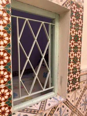 a window in a wall with colorful tiles at Dwira in Marrakech