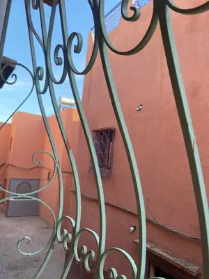 an iron gate with a building in the background at Dwira in Marrakech