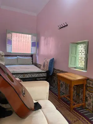a room with a couch and a bed and a table at Dwira in Marrakech