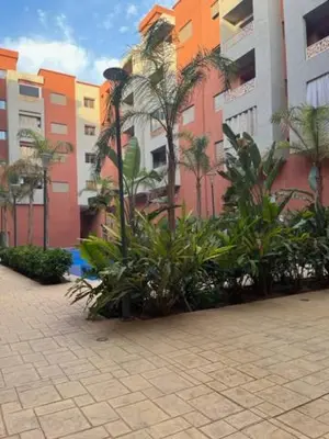 a group of palm trees and buildings in a city at ASAMA appartement avec piscine et terrasse, proche du centre in Marrakech