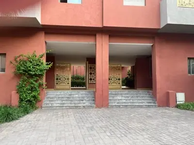 a pink building with stairs in front of it at ASAMA appartement avec piscine et terrasse, proche du centre in Marrakech