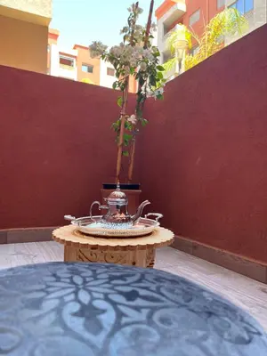 a table with a vase sitting on top of it at ASAMA appartement avec piscine et terrasse, proche du centre in Marrakech