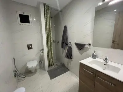 a white bathroom with a toilet and a sink at ASAMA appartement avec piscine et terrasse, proche du centre in Marrakech