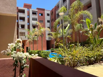 a garden in the middle of a building with plants at ASAMA appartement avec piscine et terrasse, proche du centre in Marrakech