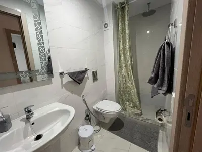 a bathroom with a sink and a toilet and a shower at ASAMA appartement avec piscine et terrasse, proche du centre in Marrakech
