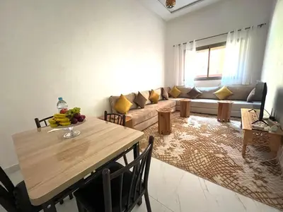 a living room with a table and a couch at ASAMA appartement avec piscine et terrasse, proche du centre in Marrakech