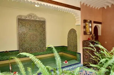 a swimming pool in a room with a tile wall at Riad Manissa in Marrakech