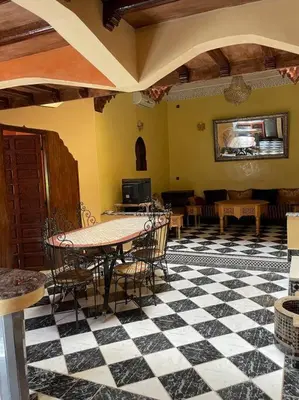 a room with a table and chairs on a checkered floor at Dxb Riad 4 suites in Marrakech