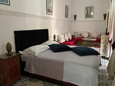 a bedroom with a large bed and a red couch at Riad Syba in Marrakech