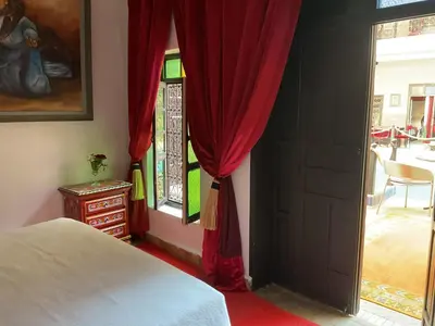 a bedroom with a bed and a red curtain at Riad Syba in Marrakech
