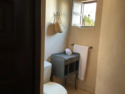 a bathroom with a toilet and a window at Riad Syba in Marrakech