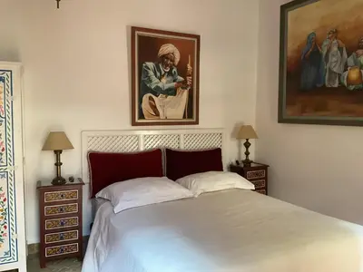 a bedroom with a bed and a painting on the wall at Riad Syba in Marrakech