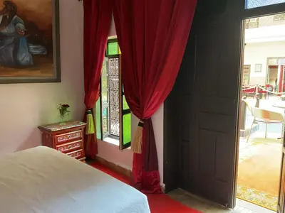 a bedroom with a bed and a red curtain at Riad Syba in Marrakech