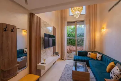 a living room with a blue couch and a tv at Duplex Haut Standing 24 in Marrakech