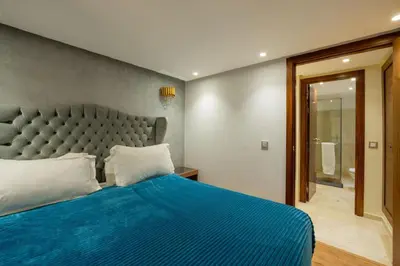 a bedroom with a blue bed with a large headboard at Duplex Haut Standing 24 in Marrakech