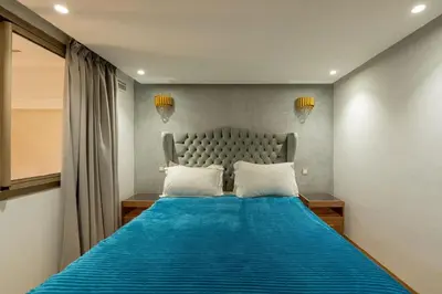 a bedroom with a blue bed with two pillows at Duplex Haut Standing 24 in Marrakech
