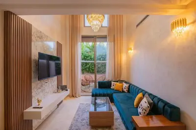 a living room with a blue couch and a tv at Duplex Haut Standing 24 in Marrakech