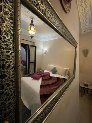 a mirror reflecting a bed in a room at Dar Nossa in Marrakech