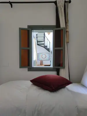 a bed with a red pillow in a room with a window at RZ22, 5 min de Jemaa El Fna, 4 Pers, Fibre Optique Wi-Fi in Marrakech