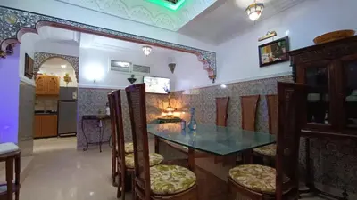 a dining room with a table and chairs at Riad à Marrakech dans la Résidence Touristique Al Qaria Assiyahia in Marrakech