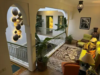 a living room with a staircase and a living room with a couch at Riad Dar Adal exclusivité 2 à 6 personnes petit déjeuner compris place jemaa El fna in Marrakech