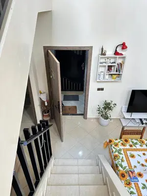 a living room with a staircase and a television at charming room close to Marrakech airport in Marrakech