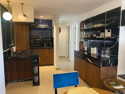 a kitchen with a counter and a blue chair at Luxueux Appart Hivernage avec vue sur L''Atlas in Marrakech