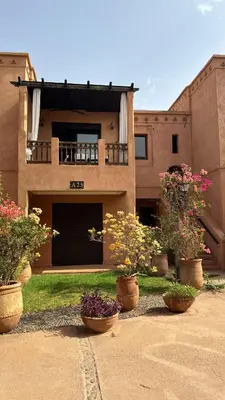 a house with potted plants in front of it at appartement dans Jardin de l'atlas in Marrakech