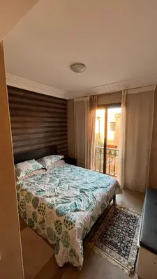 a bedroom with a large bed and a window at appartement dans Jardin de l'atlas in Marrakech