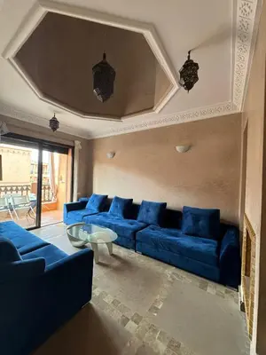 a living room with blue couches and a table at appartement dans Jardin de l'atlas in Marrakech