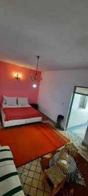 a bedroom with a red bed and a red rug at marrakesh riad in Marrakech