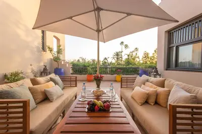 a living room with two couches and an umbrella at Luxury Villa GoldPalm Marrakech in Marrakech