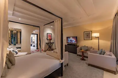 a bedroom with a large bed and a living room at Luxury Villa GoldPalm Marrakech in Marrakech