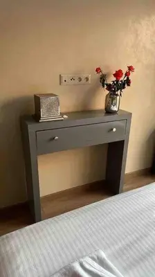 a gray table with a vase with flowers on it at APP. Traversant au GUELIZ + Piscine sur le toit in Marrakech