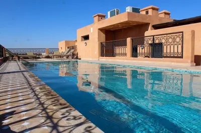 a swimming pool in front of a building at APP. Traversant au GUELIZ + Piscine sur le toit in Marrakech