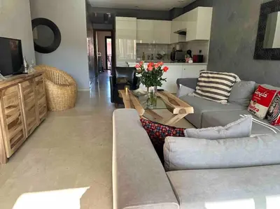 a living room with a couch and a table at APP. Traversant au GUELIZ + Piscine sur le toit in Marrakech