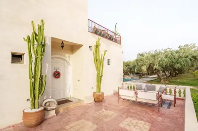 a patio with two potted plants and a white house at Villa Souad 5 Suites - Parking & Piscine Privée in Marrakech