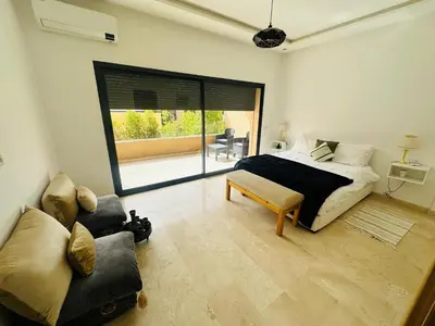 a bedroom with a bed and a couch and a window at Family Palms Luxe Villa Marrakech with Private Pool in Marrakech